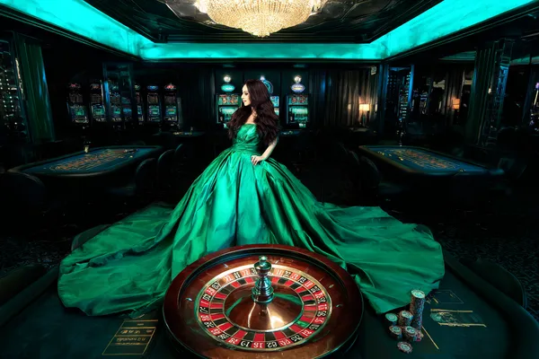 A woman in a luxurious green gown next to an ornate roulette wheel, capturing the upscale casino mood of JLWAFA.